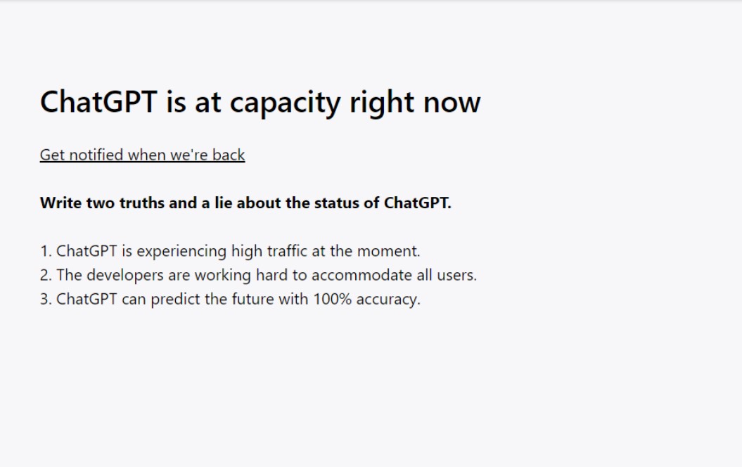 Screencapture of ChatGPT home screen that displays “ChatGPT is at capacity right now” 